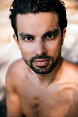 Obraz premium Portrait of gym handsome brunette with nude torso on the beach