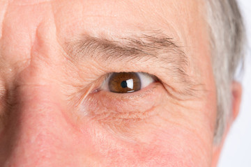 Close-up view on the eye of senior man. Horizontal photo