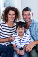 Portrait of happy family sitting together on sofa