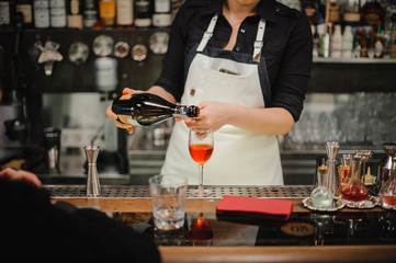 Bartender pouring champagne into glass, close-up