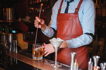 Bartender is stirring cocktails on the bar counter