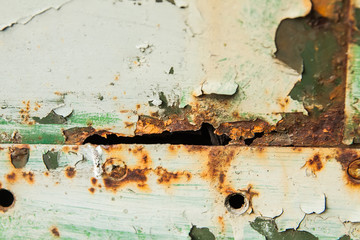 close-up old rusty grill wall. grunge background.shelled green paint