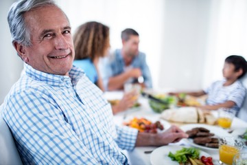 Fototapeta na wymiar Portrait of senior man sitting at dinning table