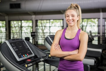 Fototapeta na wymiar Beautiful woman standing on treadmill at gym