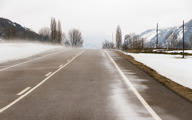 Obraz na płótnie Canvas Carretera de Montaña en paisaje nevado y ventisca de nieve