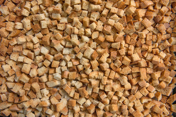Dried and browned in oven diced bread as background.
