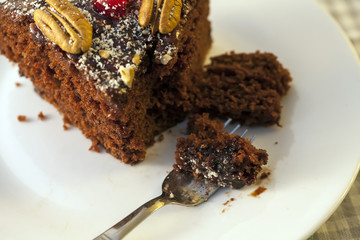 Slice of Homemade Chocolate Cake with Cherries and Pecan Nuts