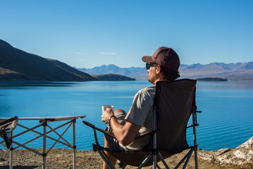 Men Camper drinking Coffee at Lake Tekapo, New Zealand 