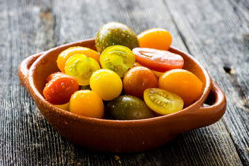 Delicious organic cherry tomatoes on a wooden background