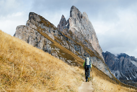 Man with a backpack walking mountain trails. In the background rocky mountains. Dolomite, Alps