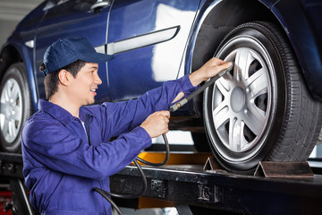 Fototapeta na wymiar Mechanic Inflating Car Tire