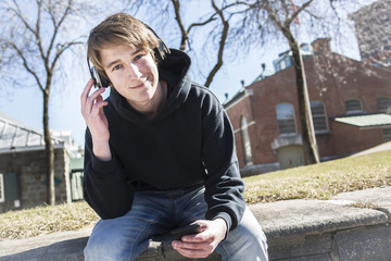 teen listening music and looking at phone