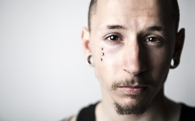 Obraz premium Handsome stylish young man with tattoo and piercing
