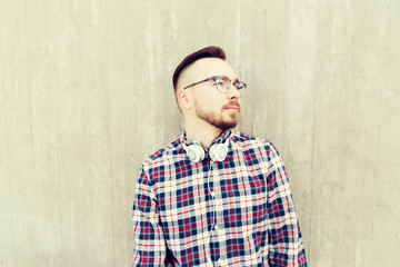 happy young hipster man with headphones over wall