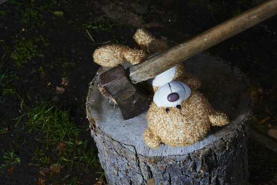 execution a teddy bear toy with an ax
