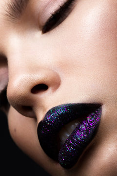 Portrait of a beautiful girl. Brilliant glossy lips closeup. Purple glitter on black lipstick