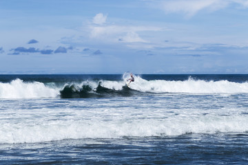 Surfer at the wave in Bali surfing spot