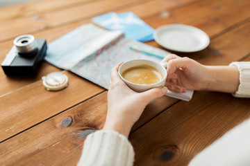 close up of hands with coffee cup and travel stuff