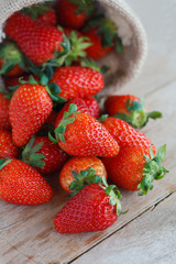 strawberries in small sack on wooden table background