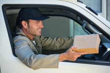 Smiling delivery man sitting in his van