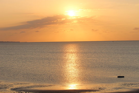 Orange golden sunrise over the Indian Ocean in Vilankulo with one fishing boat