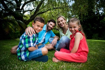 Fototapeta premium Happy family siting on grass in yard 