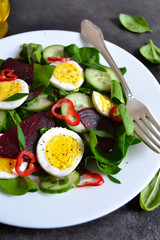 Vitamin salad with spinach, egg and beetroot on a black backgrou
