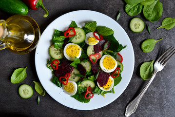 Vitamin salad with spinach, egg and beetroot on a black backgrou