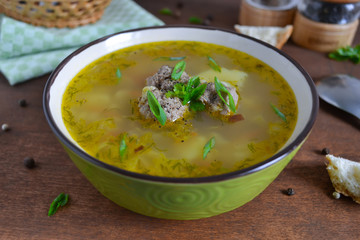 Vegetable soup with meatballs on the wooden background