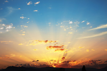 Sunset with clouds, light rays, blue sky, natural background. at