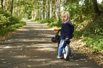 Fototapeta premium cute little girl riding runbike in summer
