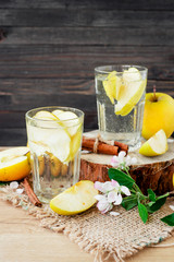 
detox , healthy and refreshing drink ,Nutritious cold sparkling water with fresh apple and cinnamon on a wooden background