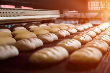 Rolgordijnen Dessertbrood bakken in de oven. Productieoven bij de bakkerij. Brood bakken. Vervaardiging van brood. © DenisProduction.com