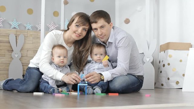 family with children building a house out of wooden designer