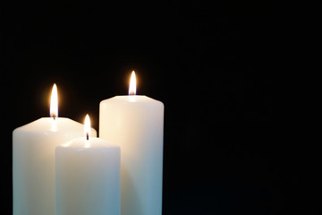 burning candles isolated on black background.