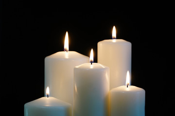 Fototapeta na wymiar burning candles isolated on black background.