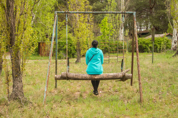 Young woman riding on a swing 