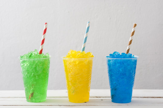 Colorful summer slushies on white wood
