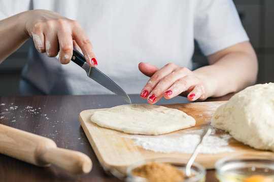 woman cuts the dough for preparing cookies