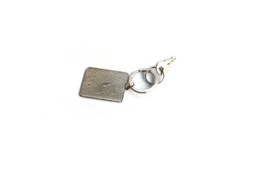 Key with rectangle key chain on white background.