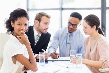 Portrait of businesswoman sitting with hand on chin in office