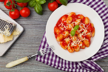 Serving gnocchi in tomato sauce with cheese.