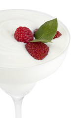 glass of white cream with raspberries