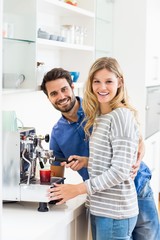 Fototapeta premium Young couple preparing coffee from coffeemaker