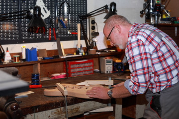 Mann beim Gitarrenbau
