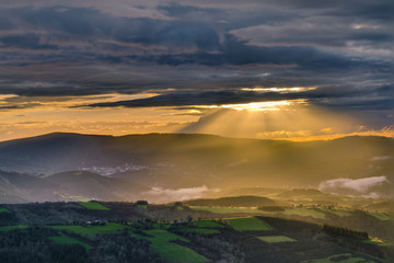 Obraz premium Sunbeams through the clouds at sunset