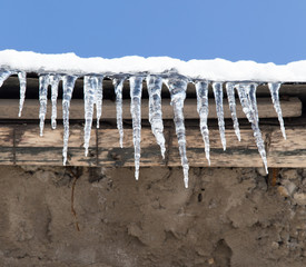icicles on a roof of a house in winter