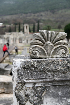 a historical marble detail and tourists in Ephesus. Ephesus was an ancient Greek city on the coast of Ionia, three kilometers southwest of present-day Selçuk in İzmir Province, Turkey.