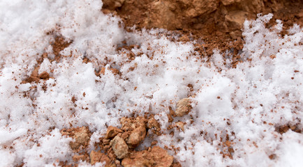 snow on red clay in nature