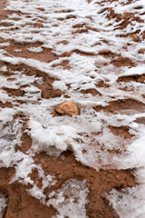 snow on red clay in nature